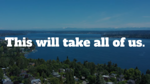 Background: Wide shot of Lake Washington, looking over the Evergreen Point Bridge, toward the Cascades on a sunny day. Text: This will take all of us.
