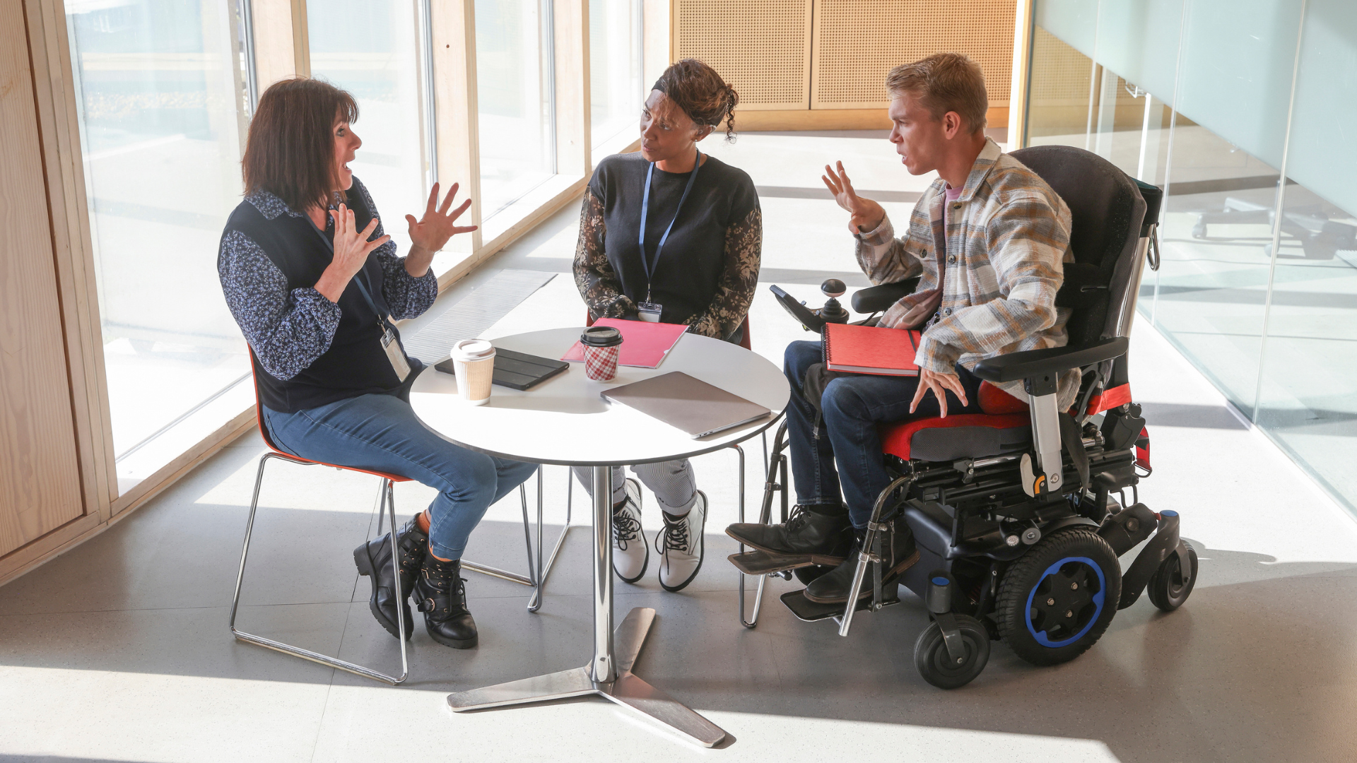 Three service provider staff meet at a table and discuss work