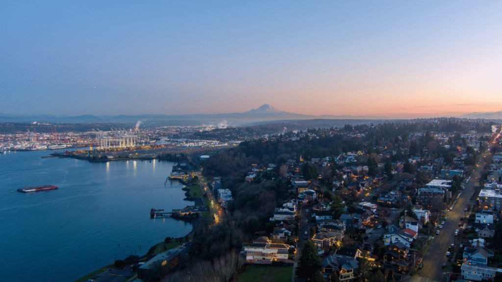 An aerial shot overlooking West Seattle and Harbor Island, looking down the Duwamish and toward South Park at dusk. Mt Rainier is in the background.